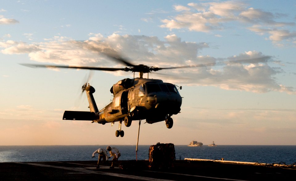US Navy 110930-N-TZ605-028 Supply department Sailors run clear after securing cargo to an SH-60F Sea Hawk helicopter assigned to Helicopter Anti-su