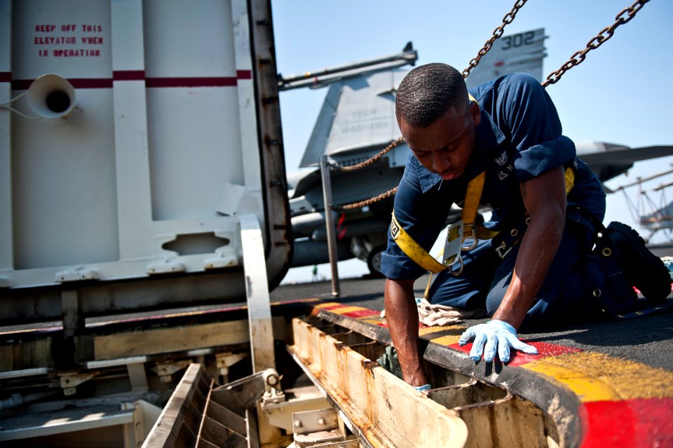 US Navy 110928-N-BT887-056 Aviation Ordnanceman Airman Anthony Washington, from Memphis, Tenn., performs maintenance on a weapons elevator aboard t