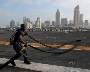 US Navy 110929-N-DX615-021 Aviation Boatswain's Mate (Fuels) 2nd Class Patrick Adjei prepares fuel hoses for flight operations aboard the amphibiou