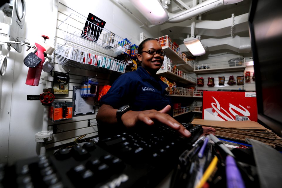 US Navy 111002-N-YZ751-026 Ship's Serviceman Seaman Andra S. McKinney totals a sale in the ship store aboard the guided-missile destroyer USS Truxt