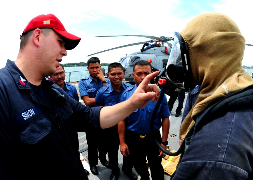 US Navy 111003-N-ED900-222 Damage Controlman 1st Class Chad Simon explains oxygen flow on a self-contained breathing apparatus during damage contro