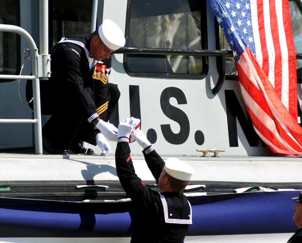 US Navy 111003-N-GL340-047 Sailors remove a pennant from a boat during the decommissioning ceremony for Maritime Expeditionary Security Squadron (M