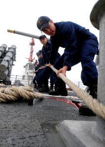 US Navy 110929-N-KB052-031 Fire Controlman 3rd Class Terry Cooper, from Long Beach, Calif., prepares to slack off on a mooring line aboard the Tico