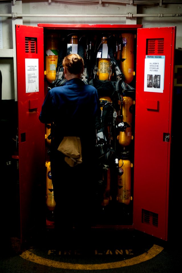US Navy 111003-N-BT887-082 Damage Controlman Fireman Carol Gonzalez, from Adrian, Mich., stows a self-contained breathing apparatus