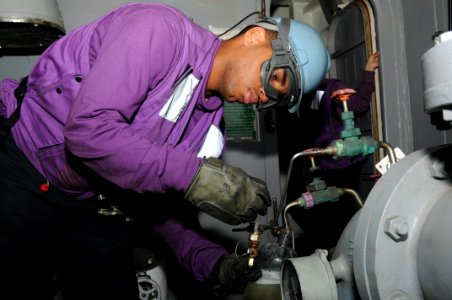US Navy 110929-N-TU894-054 Aviation Boatswain's Mate (Fuel) Airman Cliffmon G. Motley takes a fuel sample during a replenishment at sea aboard the