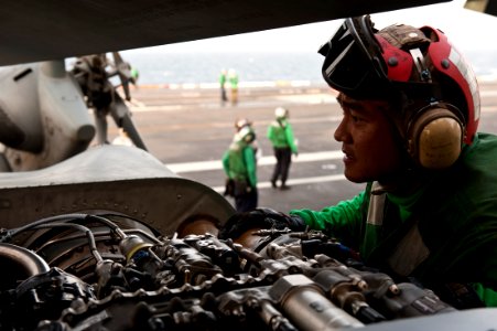 US Navy 111003-N-BT887-201 Aviation Machinist's Mate Airman Vaspol Agavatpanitch checks for foreign object debris in an MH-60R Sea Hawk helicopter