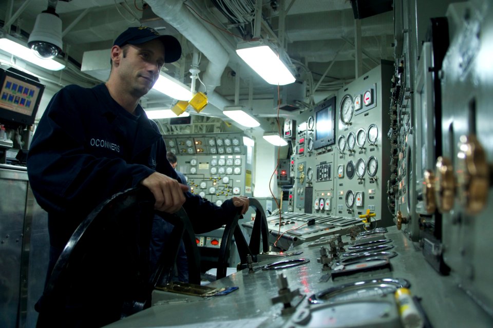 US Navy 110929-N-ZC343-983 Machinist Mate 3rd Class William Oconners stands watch in the forward main machinery room of amphibious assault ship USS