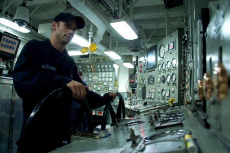 US Navy 110929-N-ZC343-983 Machinist Mate 3rd Class William Oconners stands watch in the forward main machinery room of amphibious assault ship USS