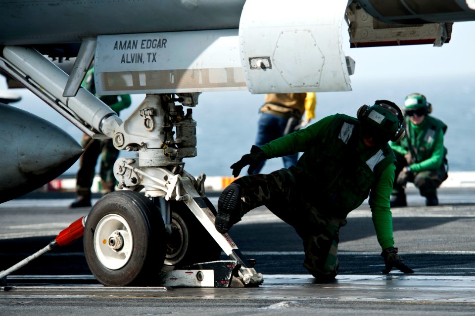 US Navy 111003-N-BT887-005 Aviation Boatswain's Mate (Equipment) Airman Juan Gutierrez secures an F-A-18F Super Hornet assigned to the Black Aces o