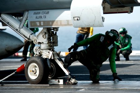 US Navy 111003-N-BT887-005 Aviation Boatswain's Mate (Equipment) Airman Juan Gutierrez secures an F-A-18F Super Hornet assigned to the Black Aces o