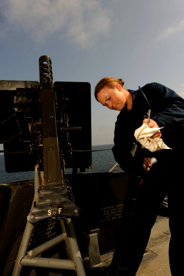 US Navy 111004-N-YZ751-005 Gunner's Mate Seaman Apprentice Lauren C. Hanley cleans a .50-caliber machine gun aboard the guided-missile destroyer US