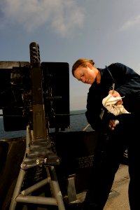 US Navy 111004-N-YZ751-005 Gunner's Mate Seaman Apprentice Lauren C. Hanley cleans a .50-caliber machine gun aboard the guided-missile destroyer US