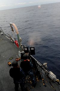 US Navy 111005-N-ED900-004 Gunner's Mate 1st Class Dominic Wayment fires a 50-caliber machine gun