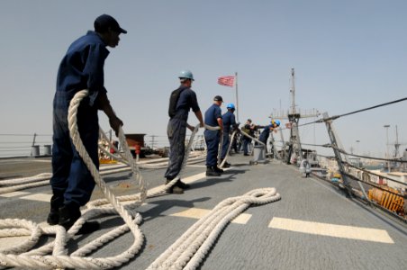 US Navy 111004-N-XQ375-080 Sailors aboard the guided-missile destroyer USS Mitscher (DDG 57) heave a line as Mitscher prepares to depart Bahrain
