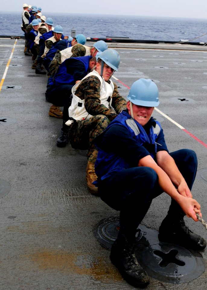 US Navy 111003-N-WJ771-152 ailors and Marines assigned to the forward-deployed amphibious transport dock ship USS Denver (LPD 9) heave around on a