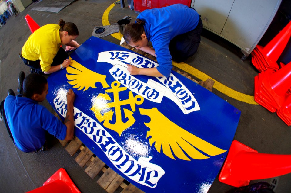 US Navy 111004-N-ZC343-089 Sailors assigned to V3 division aboard the amphibious assault ship USS Bonhomme Richard (LHD 6) finish painting a sign w