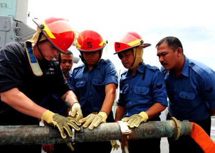 US Navy 111003-N-ED900-262 Damage Controlman 1st Class Aaron Hoke practices pipe patching with Royal Brunei Navy sailors photo