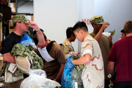 US Navy 111005-N-GT324-063 A Sailor assigned to Naval Special Warfare (NSW) Logistics Support Unit (LOGSU) 1, bags up uniform pieces