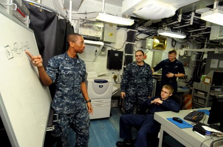 US Navy 111006-N-SF704-042 Information Systems Technician 3rd Class Rodney Adams, from Memphis, Tenn., discusses a radio and Internet protocol diag