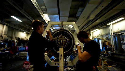 US Navy 111008-N-TU221-386 Aviation Machinist's Mate Airman Jason Nitz and Airman Stefhan Spaulding tighten screws on the frame of a jet engine ins