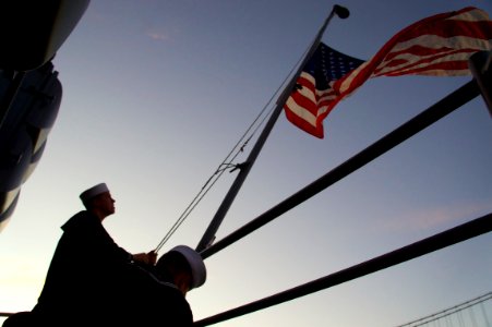 US Navy 111008-N-ZC343-229 Sailors take down the national ensign during evening colors