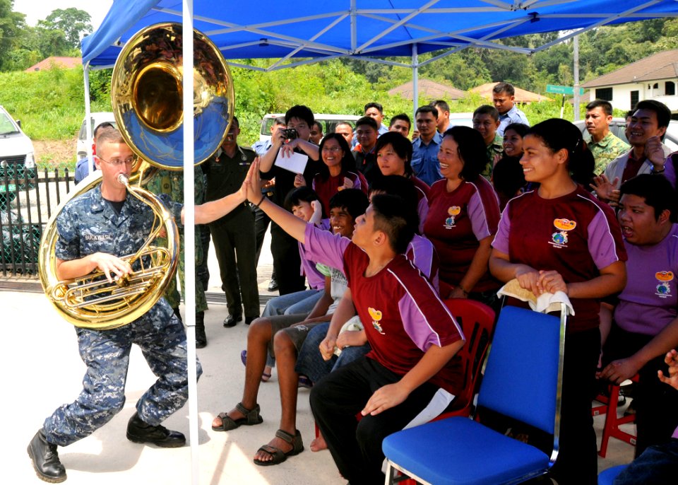 US Navy 111004-N-NJ145-131 Musician 3rd Class Zachary Buckwash receives high-fives from students as he performs with the U.S. 7th Fleet Band, Orien