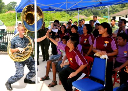 US Navy 111004-N-NJ145-131 Musician 3rd Class Zachary Buckwash receives high-fives from students as he performs with the U.S. 7th Fleet Band, Orien
