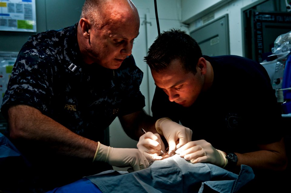 US Navy 111005-N-BT887-021 Lt. Gregory Pirkl, left, shows Hospital Corpsman 2nd Class Jason Butler the proper technique for making an incision