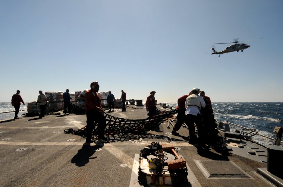 US Navy 111005-N-XQ375-203 Sailors unload supplies on the flight deck of the guided-missile destroyer USS Mitscher (DDG 57) during a vertical reple