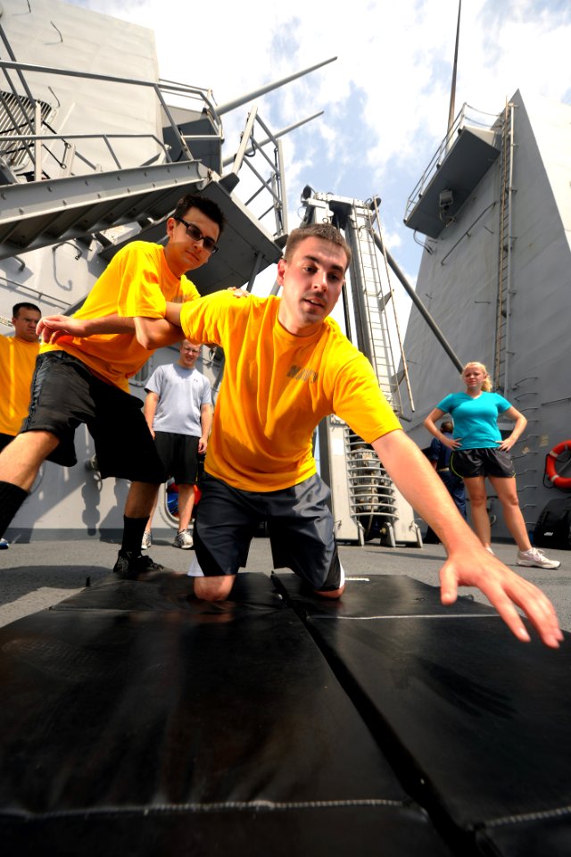 US Navy 111005-N-YZ751-156 Hull Maintenance Technician Fireman Recruit Horacio Perez-Ramos, left, practices take down techniques with Electronics T