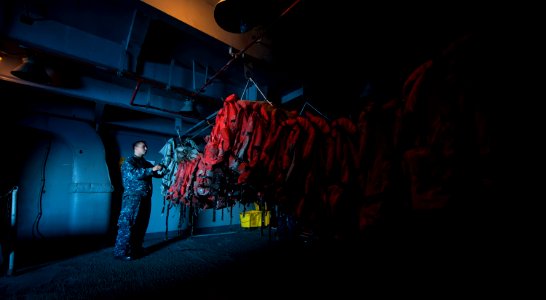 US Navy 111008-N-TU221-298 Boatswain's Mate Seaman Preston Parr sorts float coats in a storage space aboard the Nimitz-class aircraft carrier USS A photo