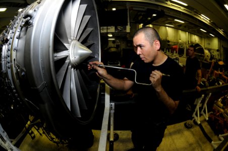 US Navy 111008-N-TU894-036 Aviation Machinist's Mate 2nd Class Ubaldo Herrera puts the nose cone on a jet engine aboard the aircraft carrier USS Ge