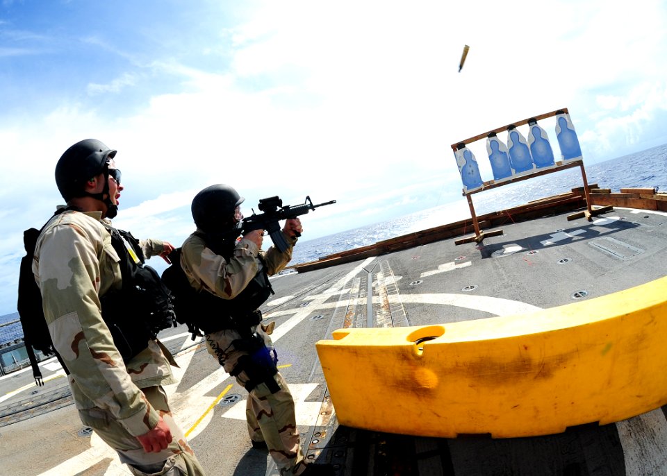 US Navy 111011-N-ED900-950 Operations Specialist Seaman Amanda Gregor fires an M4-A1 carbine