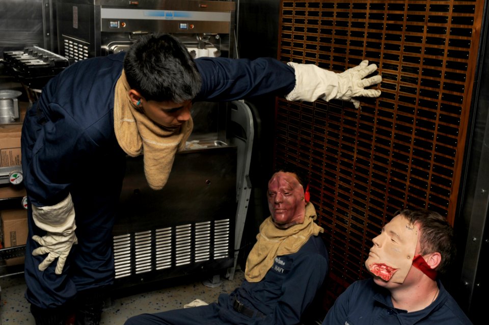 US Navy 111008-N-XQ375-040 Personnel Specialist Seaman Nick Smith, left, assesses medical casualties simulated by Damage Controlman 3rd Class Edwin