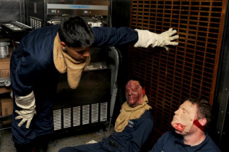 US Navy 111008-N-XQ375-040 Personnel Specialist Seaman Nick Smith, left, assesses medical casualties simulated by Damage Controlman 3rd Class Edwin