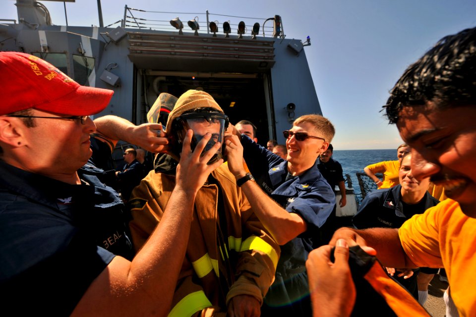 US Navy 111009-N-YZ751-014 Sailors help Cryptologic Technician (Collection) Seaman Recruit Alex J. Wright don fire-fighting equipment during a dama