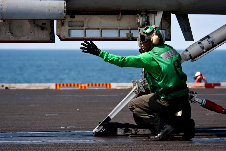 US Navy 111012-N-BT887-100 Aviation Boatswain's Mate (Equipment) 2nd Class Durante Cousins signals to load the steam-powered catapult for an F-A-18