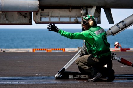 US Navy 111012-N-BT887-100 Aviation Boatswain's Mate (Equipment) 2nd Class Durante Cousins signals to load the steam-powered catapult for an F-A-18