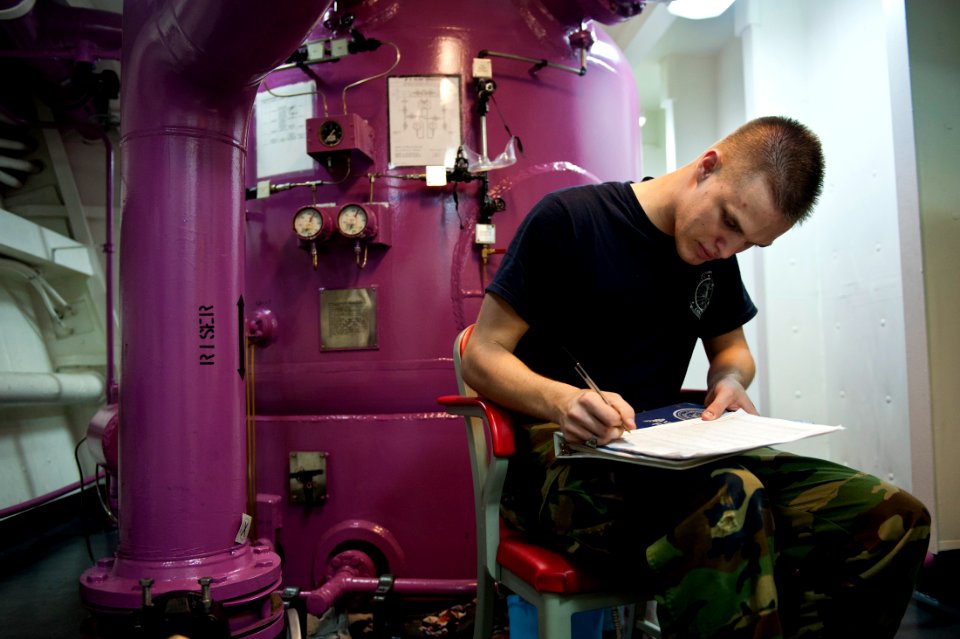 US Navy 111012-N-BT887-429 Aviation Boatswain's Mate (Fuel) Airman Daniel Langston logs fuel pressure during fuel purification