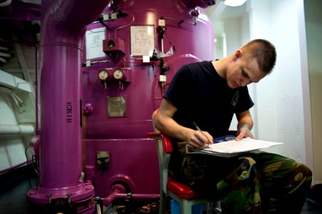 US Navy 111012-N-BT887-429 Aviation Boatswain's Mate (Fuel) Airman Daniel Langston logs fuel pressure during fuel purification