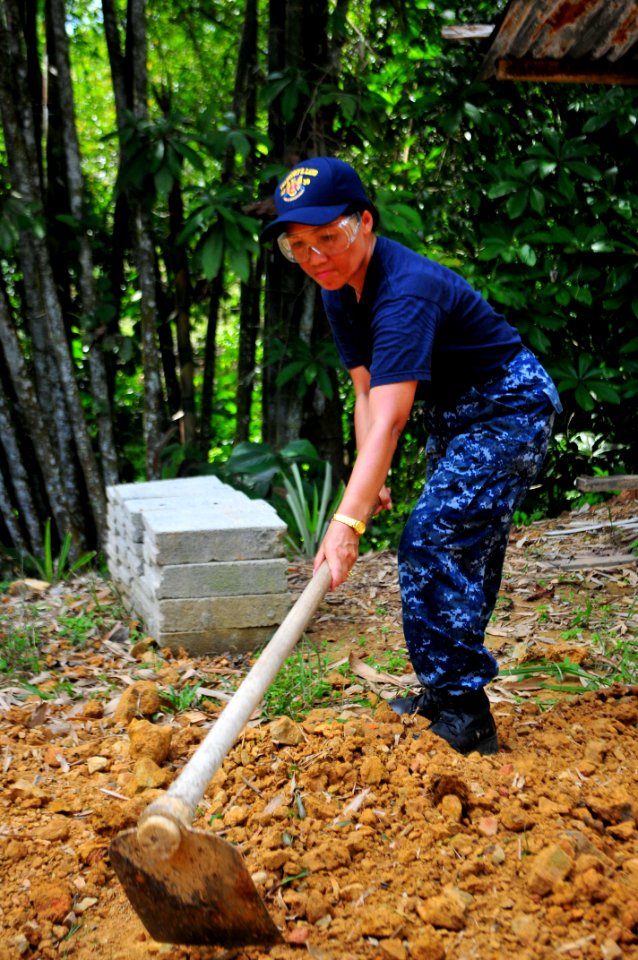 US Navy 111012-N-JH293-007 Hospital Corpsman 1st Class Eme Praska clears dirt and debris during a Habitat For Humanity community service project in