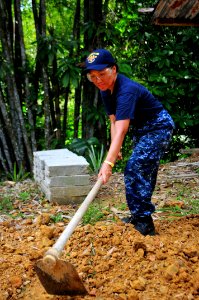 US Navy 111012-N-JH293-007 Hospital Corpsman 1st Class Eme Praska clears dirt and debris during a Habitat For Humanity community service project in