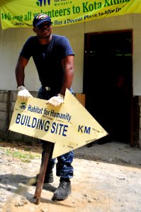 US Navy 111012-N-JH293-131 Electronics Technician 3rd Class Tarwon Koah sets up a building site sign during a Habitat For Humanity during a Habitat