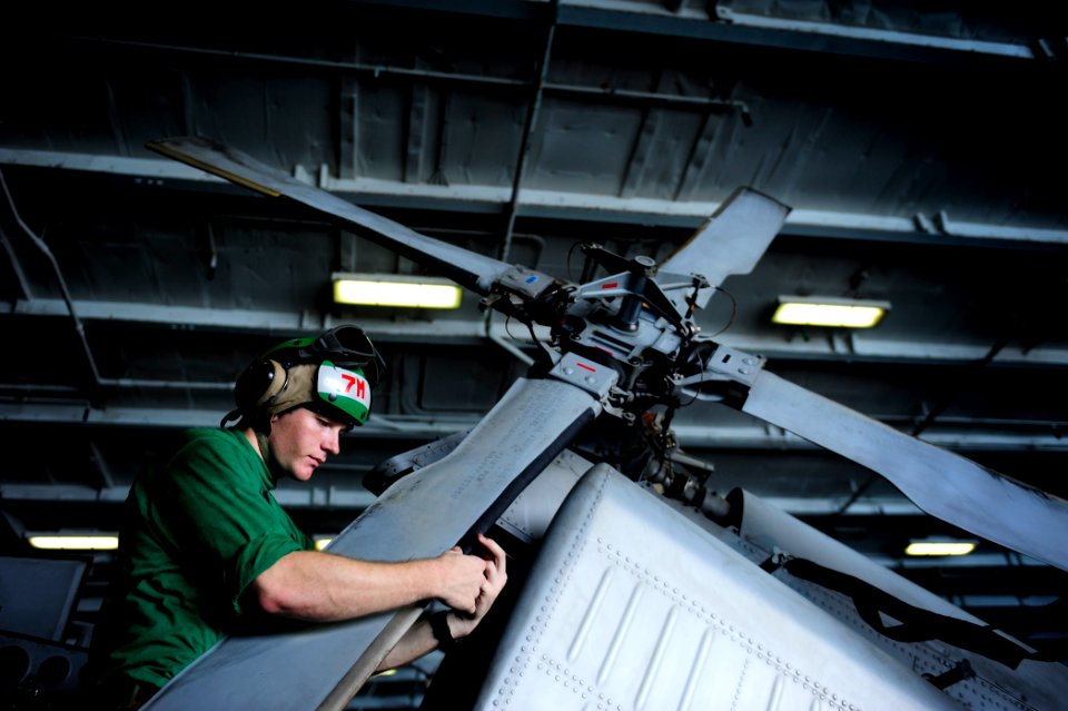 US Navy 111011-N-VN693-104 Aviation Structural Mechanic Airman Philip Alexander, from Roseville, Calif., checks the edge of a rotor blade on an MH
