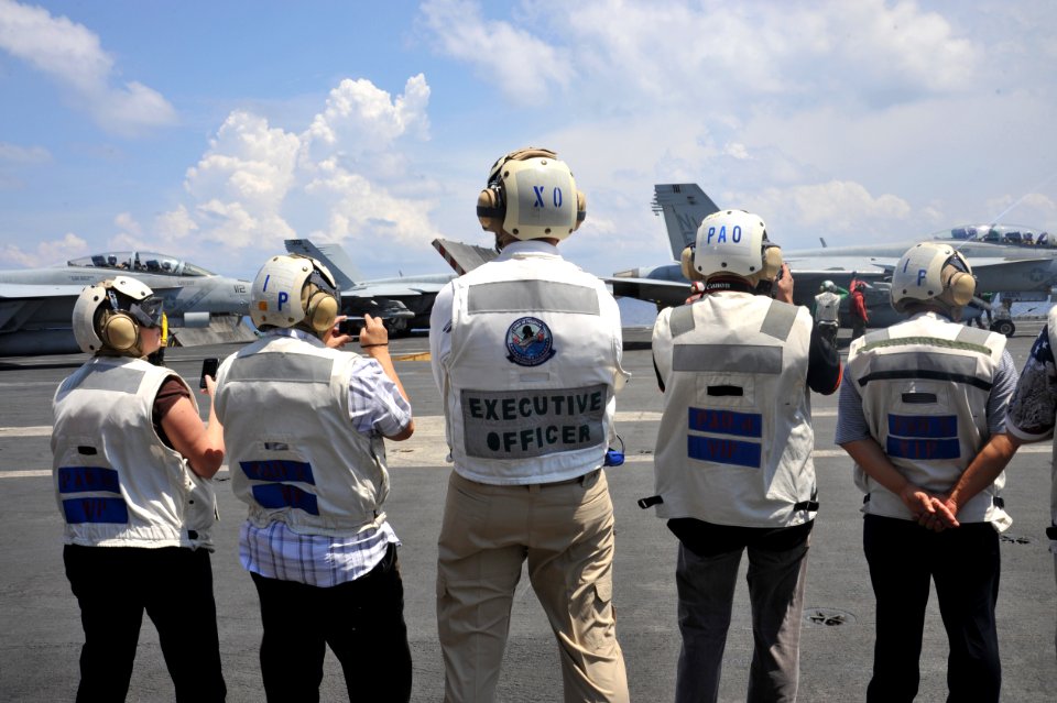 US Navy 111012-N-SF704-358 Capt. Kenneth Reynard, executive officer aboard the aircraft carrier USS George Washington (CVN 73), stands with visitor