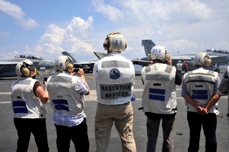 US Navy 111012-N-SF704-358 Capt. Kenneth Reynard, executive officer aboard the aircraft carrier USS George Washington (CVN 73), stands with visitor