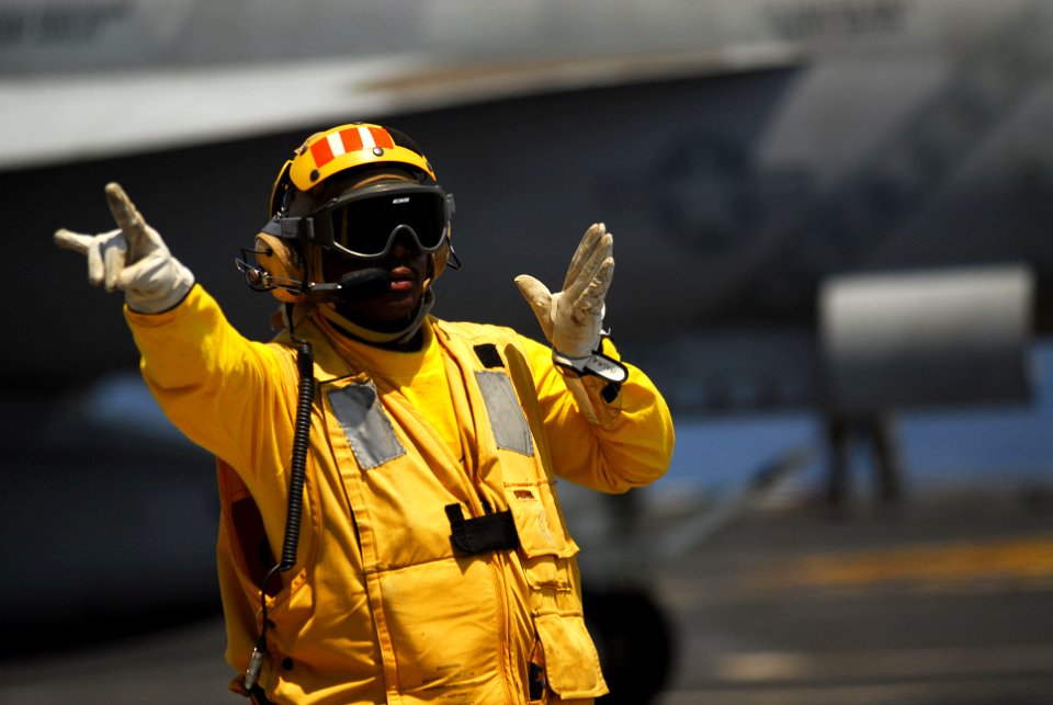US Navy 111012-N-WW409-245 Senior Chief Aviation Boatswain's Mate (Handling) Glen Newbins directs aircraft on the flight deck of the aircraft carri