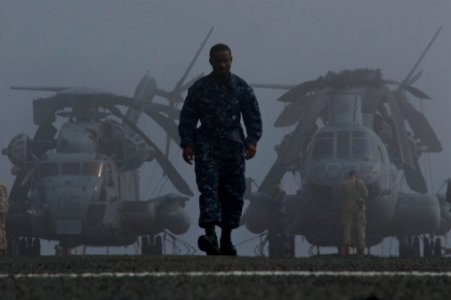 US Navy 111011-N-ZC343-440 A Sailor crosses the flight deck in front of two Marine Corps CH-53 Sea Stallion helicopter as the amphibious assault sh