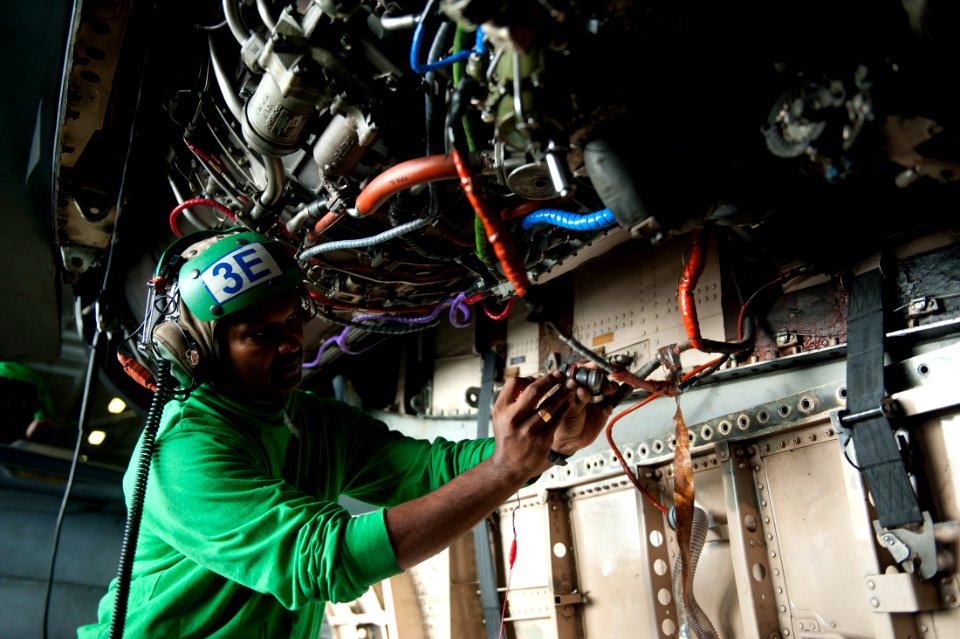 US Navy 111012-N-BT887-234 Aviation Electrician's Mate 1st Class Srisaba Selvarajah troubleshoots the engine of an F-A-18C