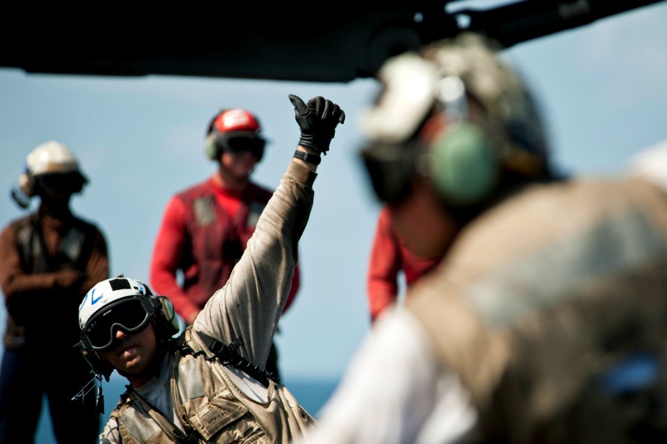 US Navy 111012-N-BT887-153 Aviation Structural Mechanic (Equipment) 3rd Class Zack Faith signals approval to launch an F-A-18C Hornet assigned to t